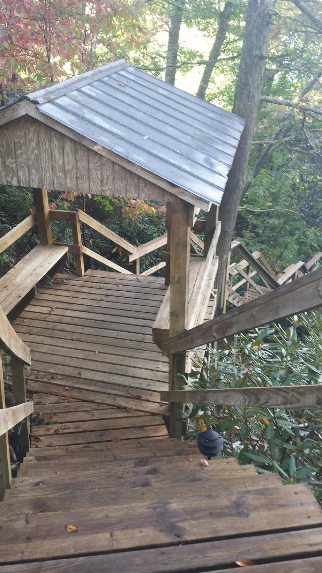 Metal roofed shelter over wooden steps on a wooded walkway — Skylight Repair & Installation work by our crew in Youngstown
