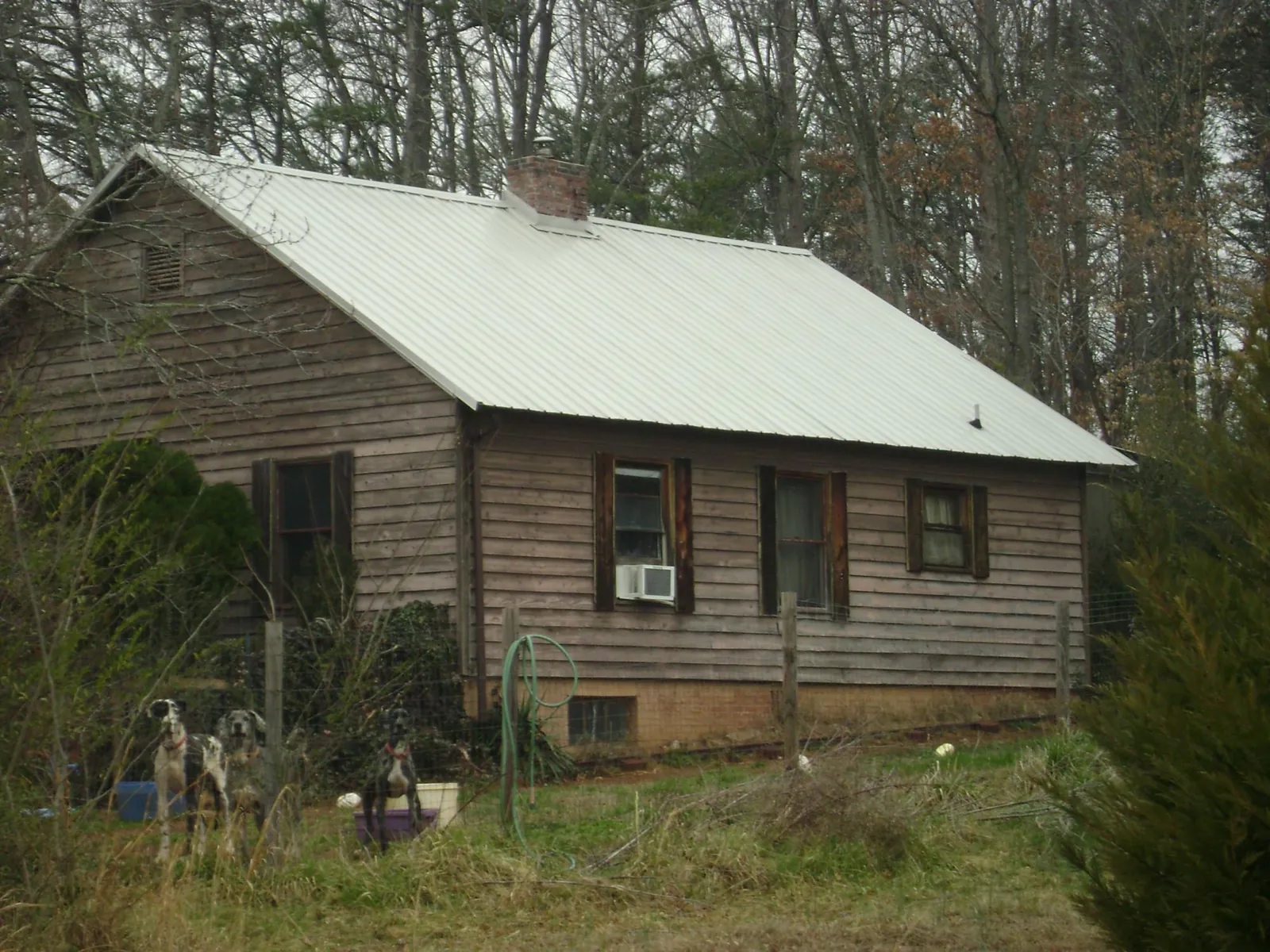 White metal roof on an old wood sided farmhouse, from a Metal Roof Installation job in Youngstown